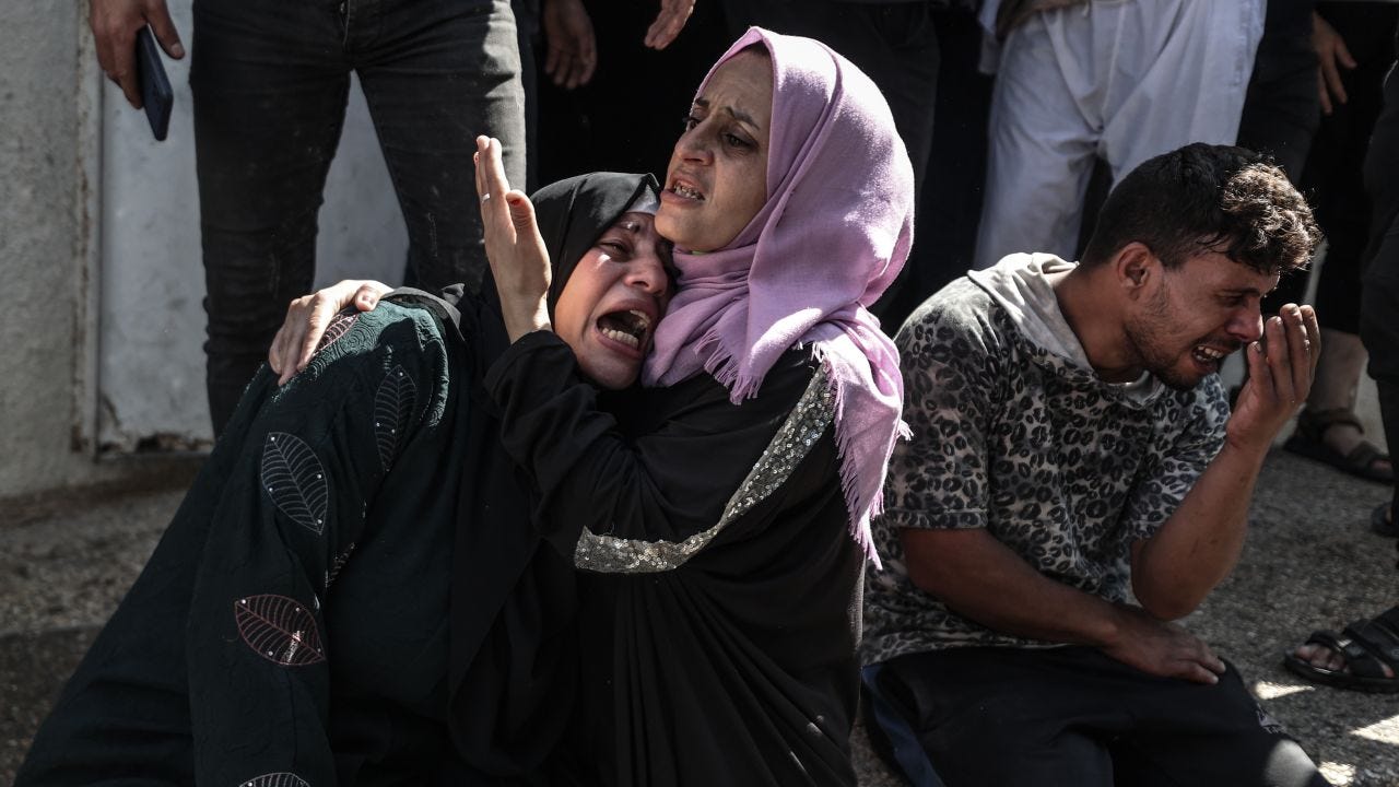  Relatives of Palestinians, killed by Israeli forces during airstrike clashes, mourn after they were taken to the morgue of Shifa Hospital in Gaza City.
