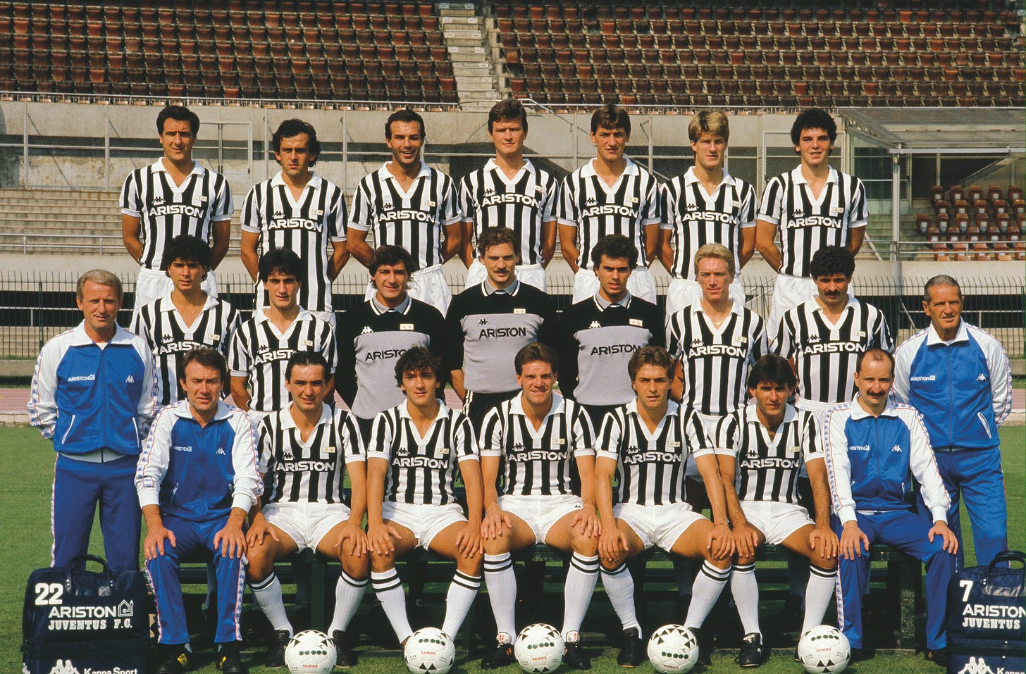 Juventus full squad photo in the 1980s wearing Ariston jerseys, with players, coaches, and staff posed together in rows at the stadium.