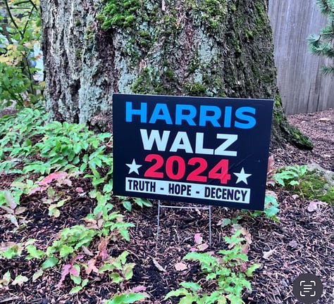 Tim Walz and his black lab, Harris Walz camo cap, Harris Watz signs, and voting