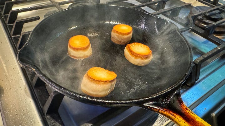 Side by side photos of the mushrooms (left) and the hearts of palm (right) which are covered in aonori flakes, searing in a cast iron skillet.