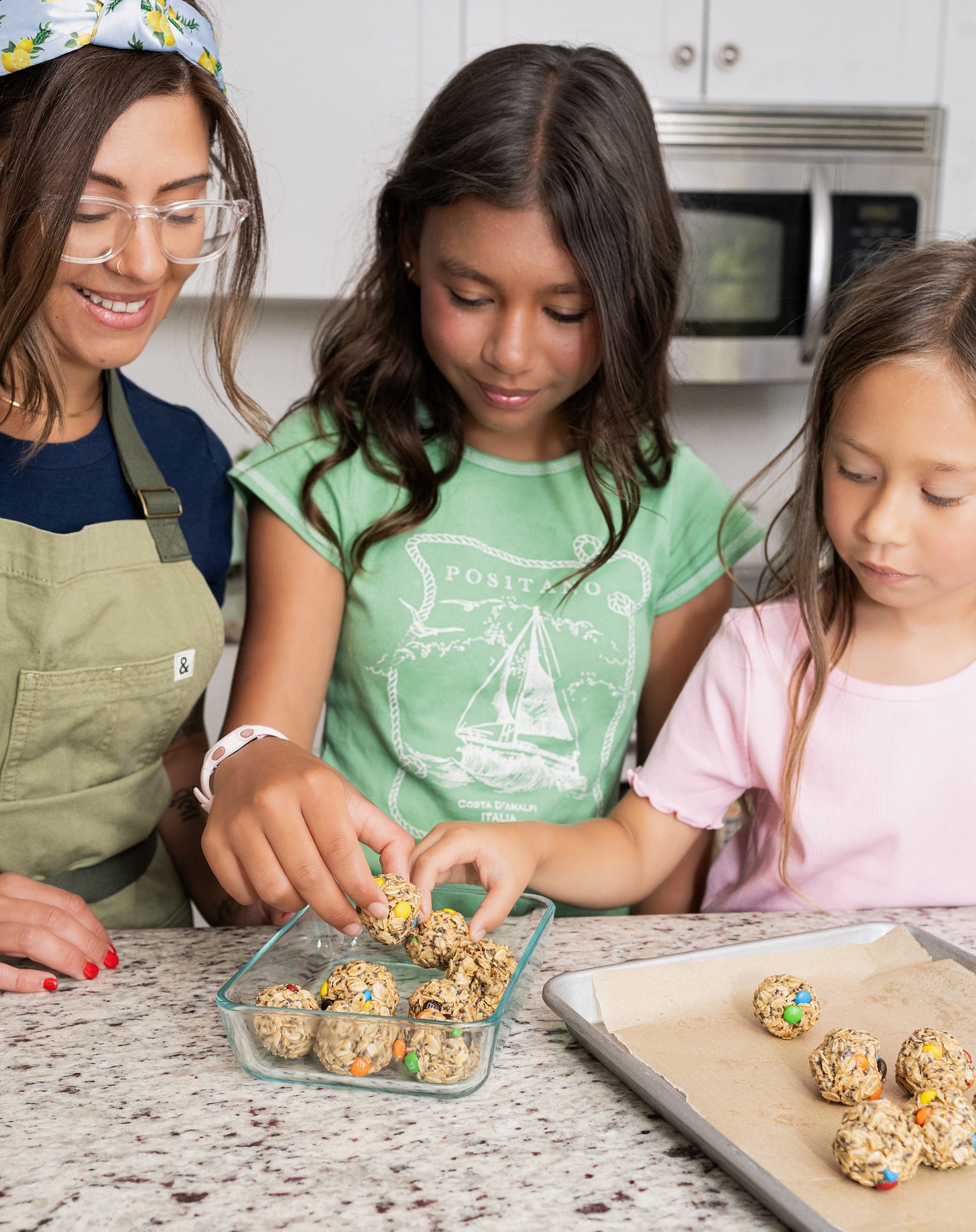 Kris and her daughters prepping snacks in a glass container Kris and her daughters prepping snacks in a glass container
