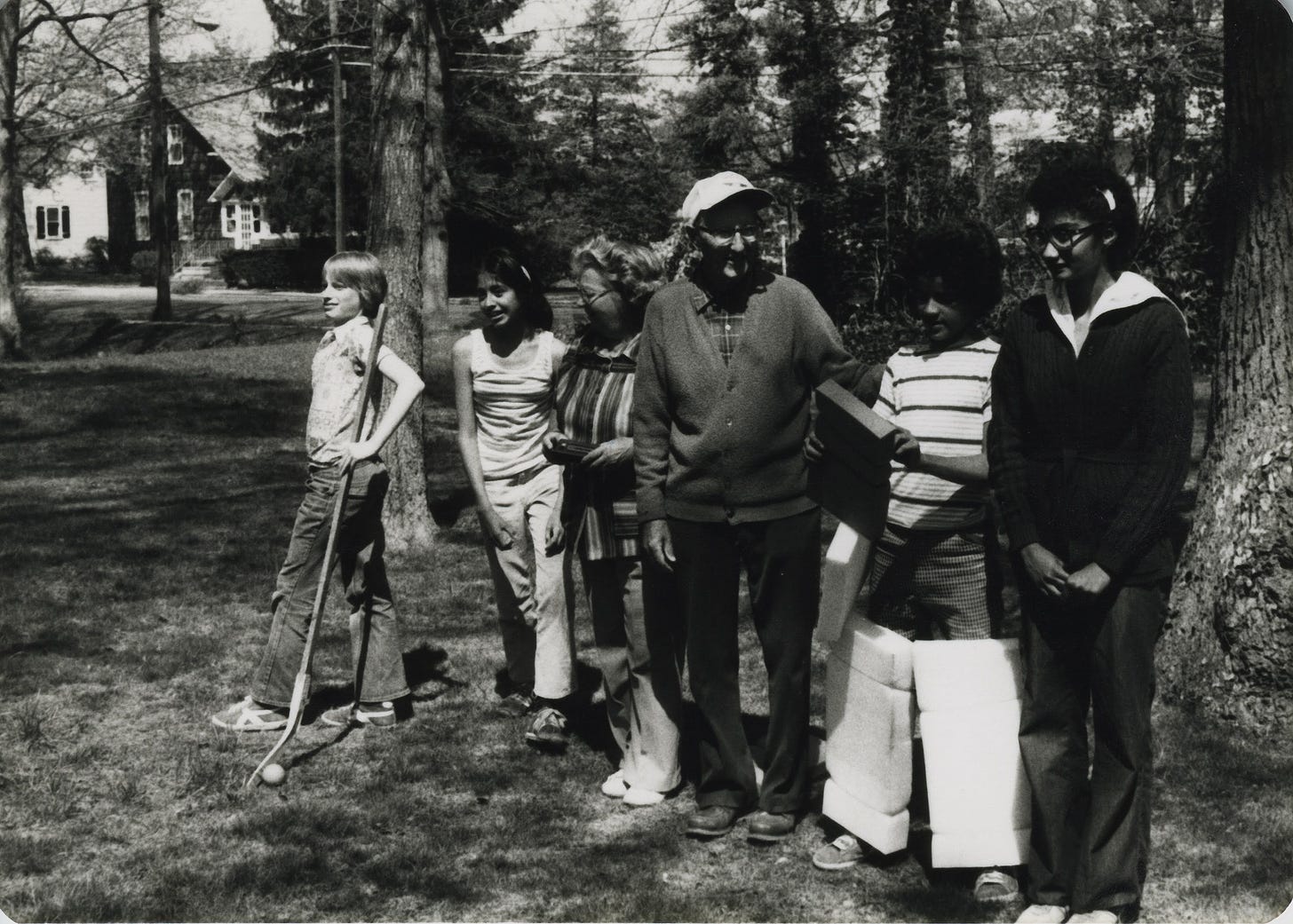 Six people outside in New Jersey, two with field hockey items Six people outside in New Jersey, two with field hockey items