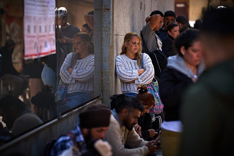 Migrants queue outside Barcelona City Hall to obtain paperwork needed to apply for Spain's immigration amnesty, 20 April, 2026