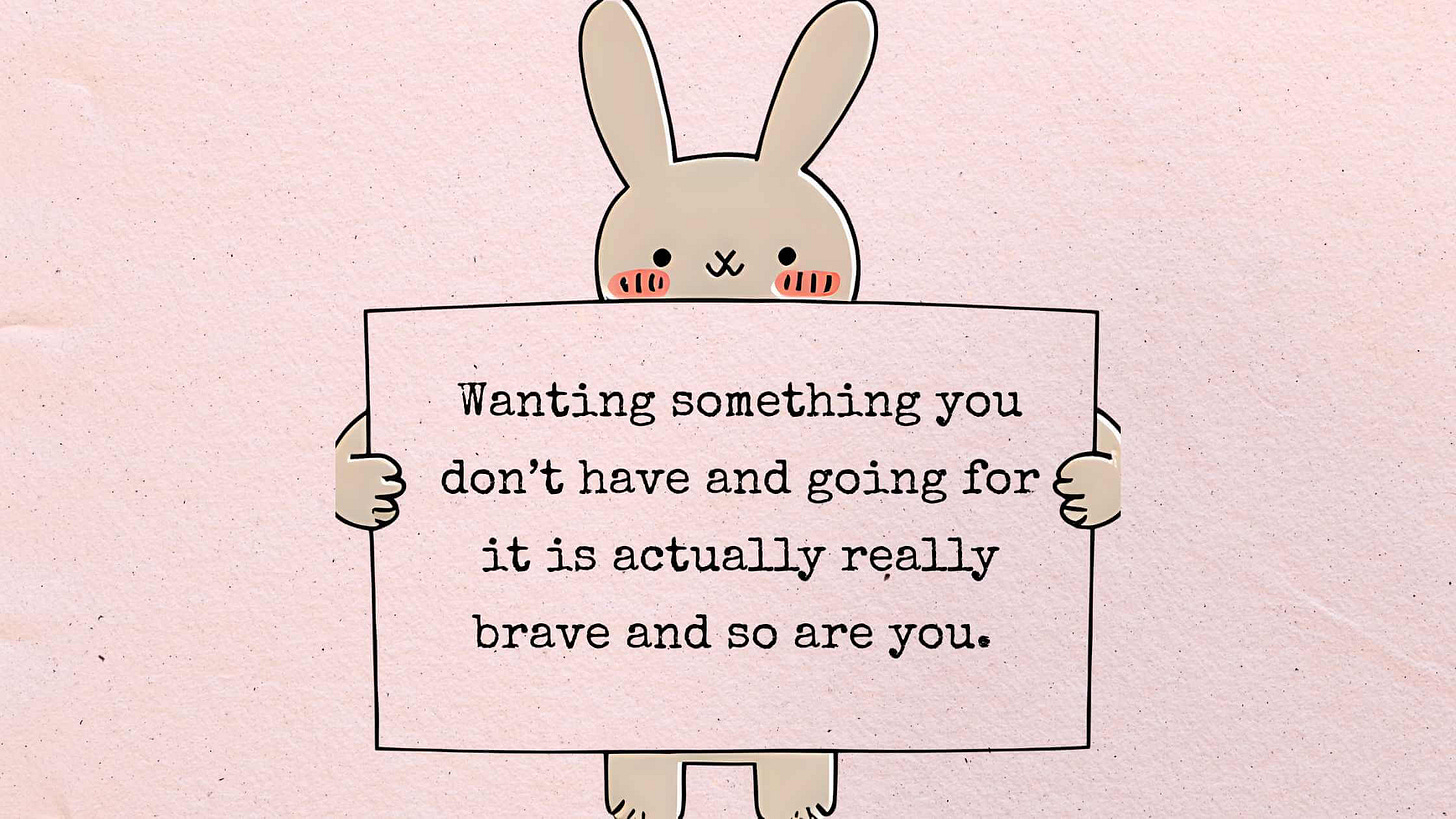 Cute bunny holding inspirational quote sign about bravery and wanting things - free motivational phone wallpaper download