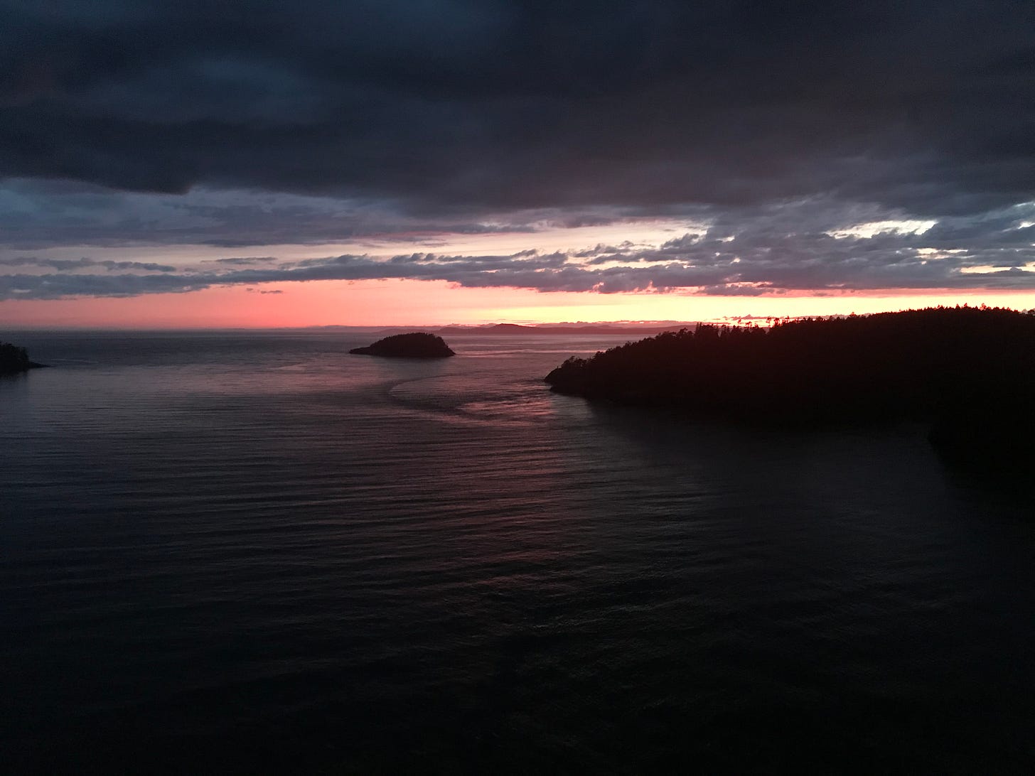 Dusk above body of water. Silhouettes of dark islands.