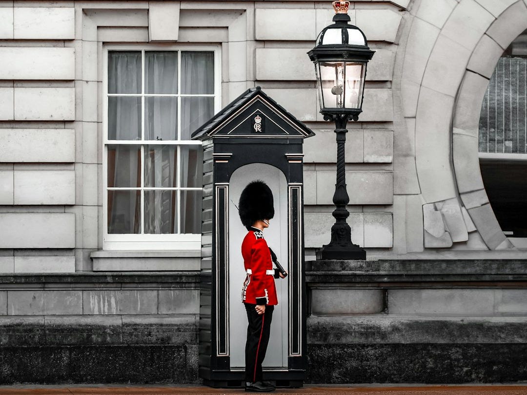 A royal guard stands outside a building A royal guard stands outside a building