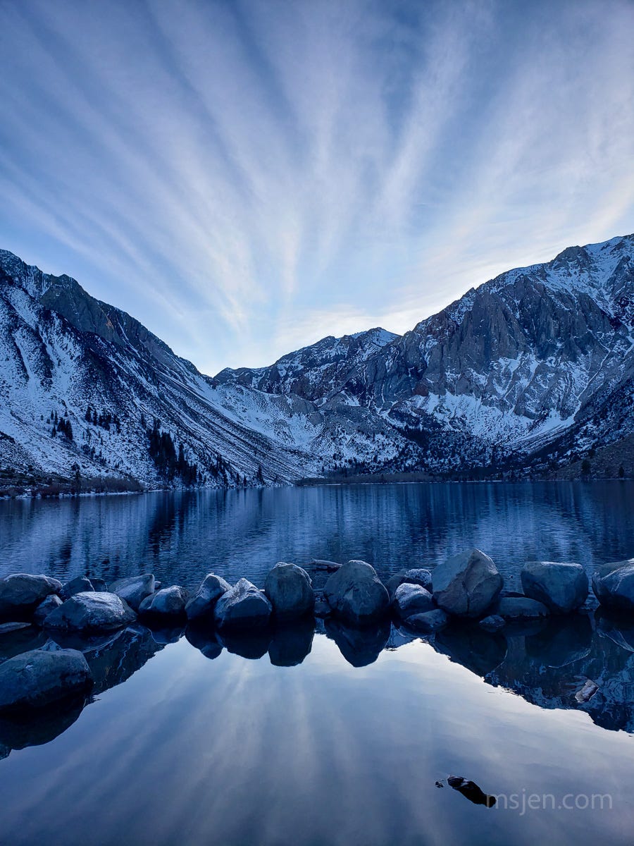 Photo of clouds and snowy mountains reflected onto the still waters of a wintery Convict Lake. Photo by Jenifer Hanen. Photo of clouds and snowy mountains reflected onto the still waters of a wintery Convict Lake. Photo by Jenifer Hanen.