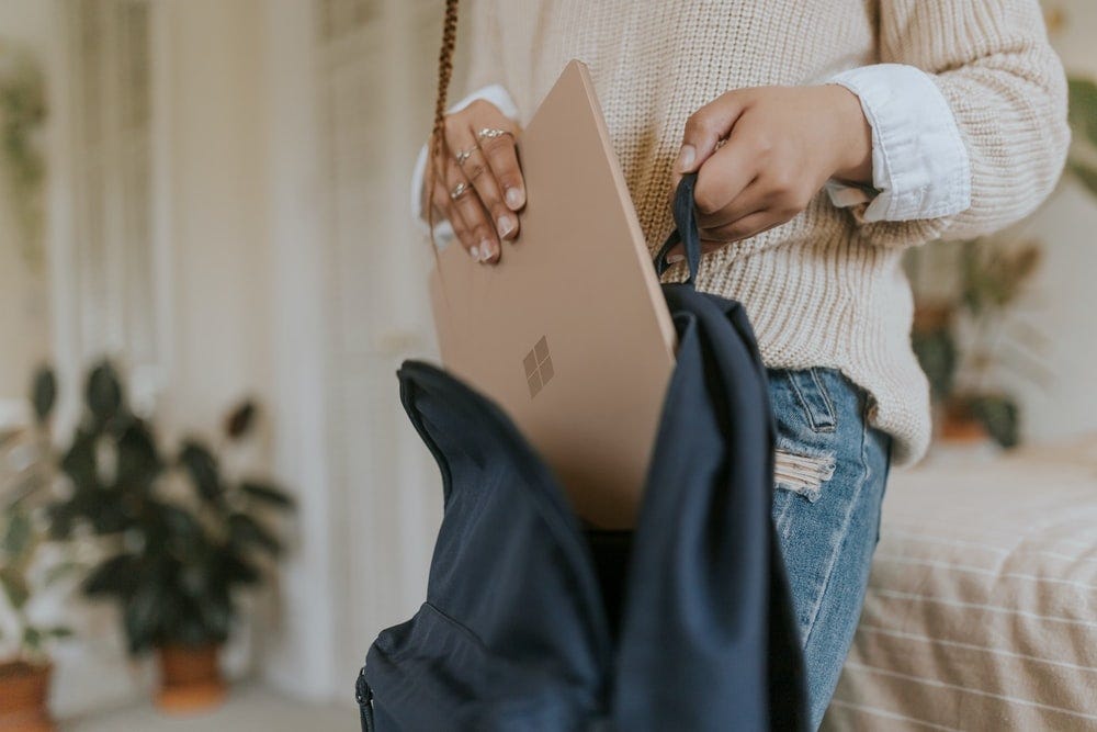 woman in blue denim jeans holding sandstone surface laptop woman in blue denim jeans holding sandstone surface laptop