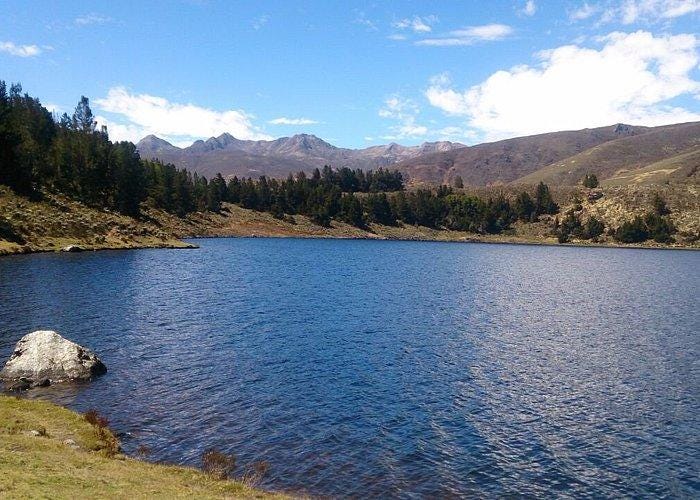 A lake with trees and mountains in the background

Description automatically generated with low confidence