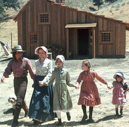 This may contain: an old photo of four people and a dog in front of a wooden house with a dog on the ground This may contain: an old photo of four people and a dog in front of a wooden house with a dog on the ground