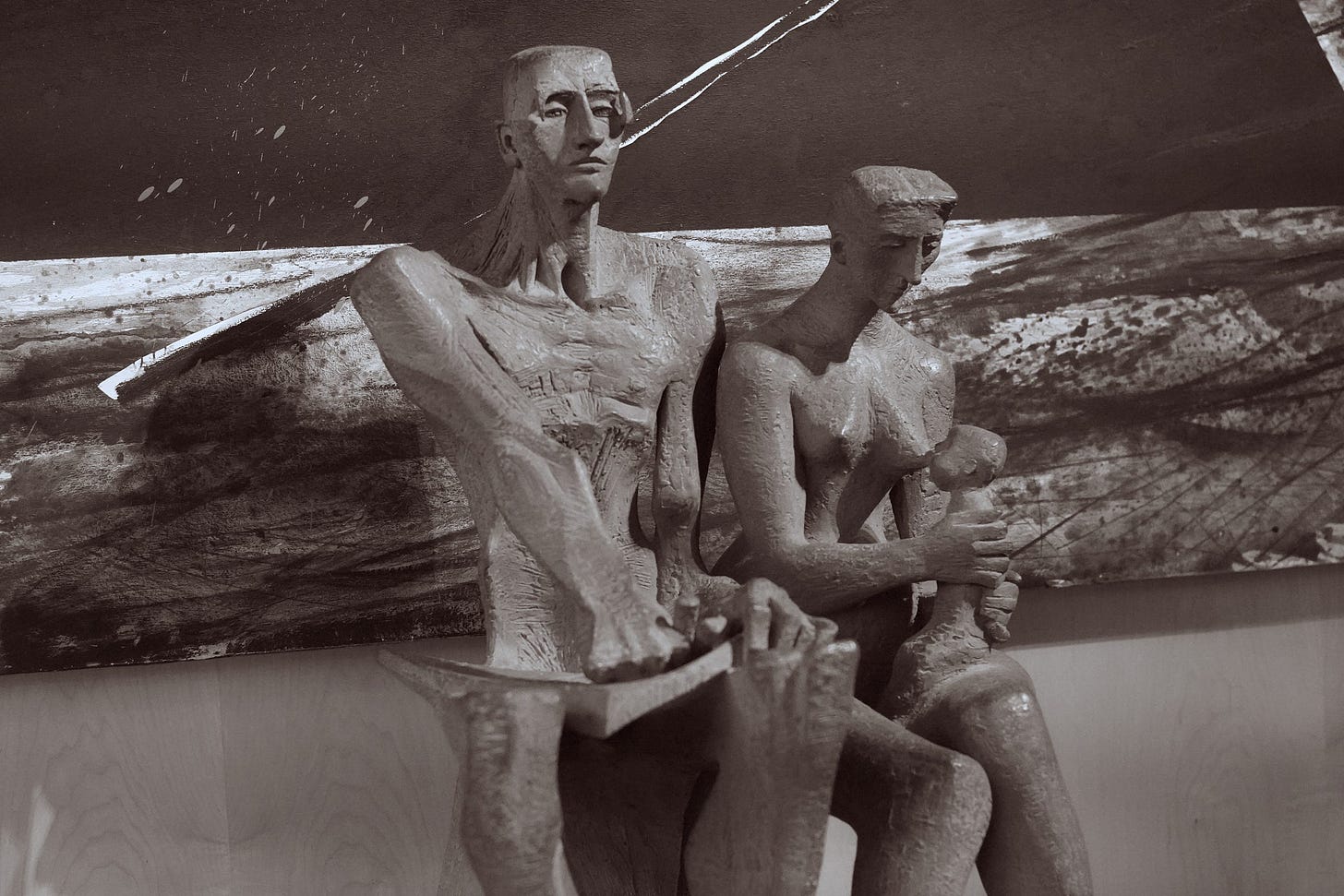 a stone statue depicting a family — a man, woman, and a breastfeeding baby