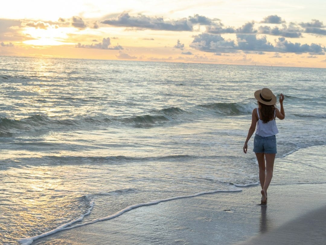 woman walking on seashore woman walking on seashore