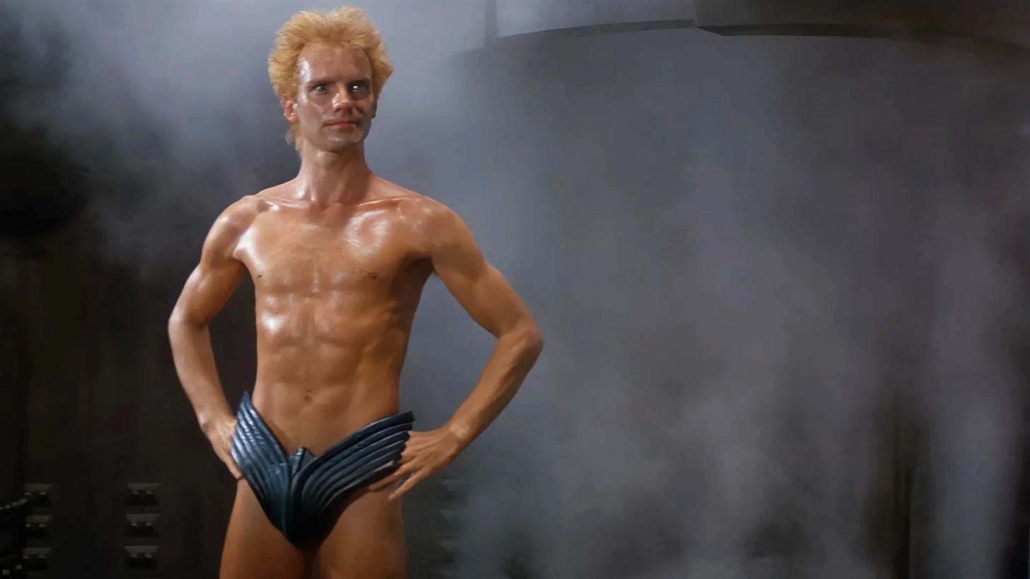 Sting in a sauna, hands on hips, wearing a striking Eagle codpiece Sting in a sauna, hands on hips, wearing a striking Eagle codpiece