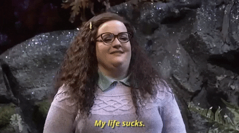 The gif shows a white women with long brown hair nodding and saying "My life sucks."