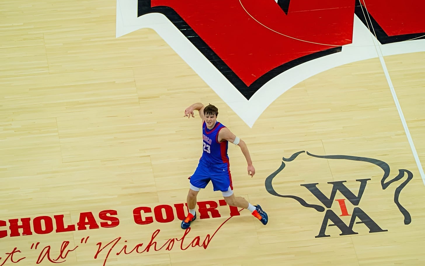 Zavier Zens celebrating on the court at the Kohl Center during a WIAA State Tournament game.