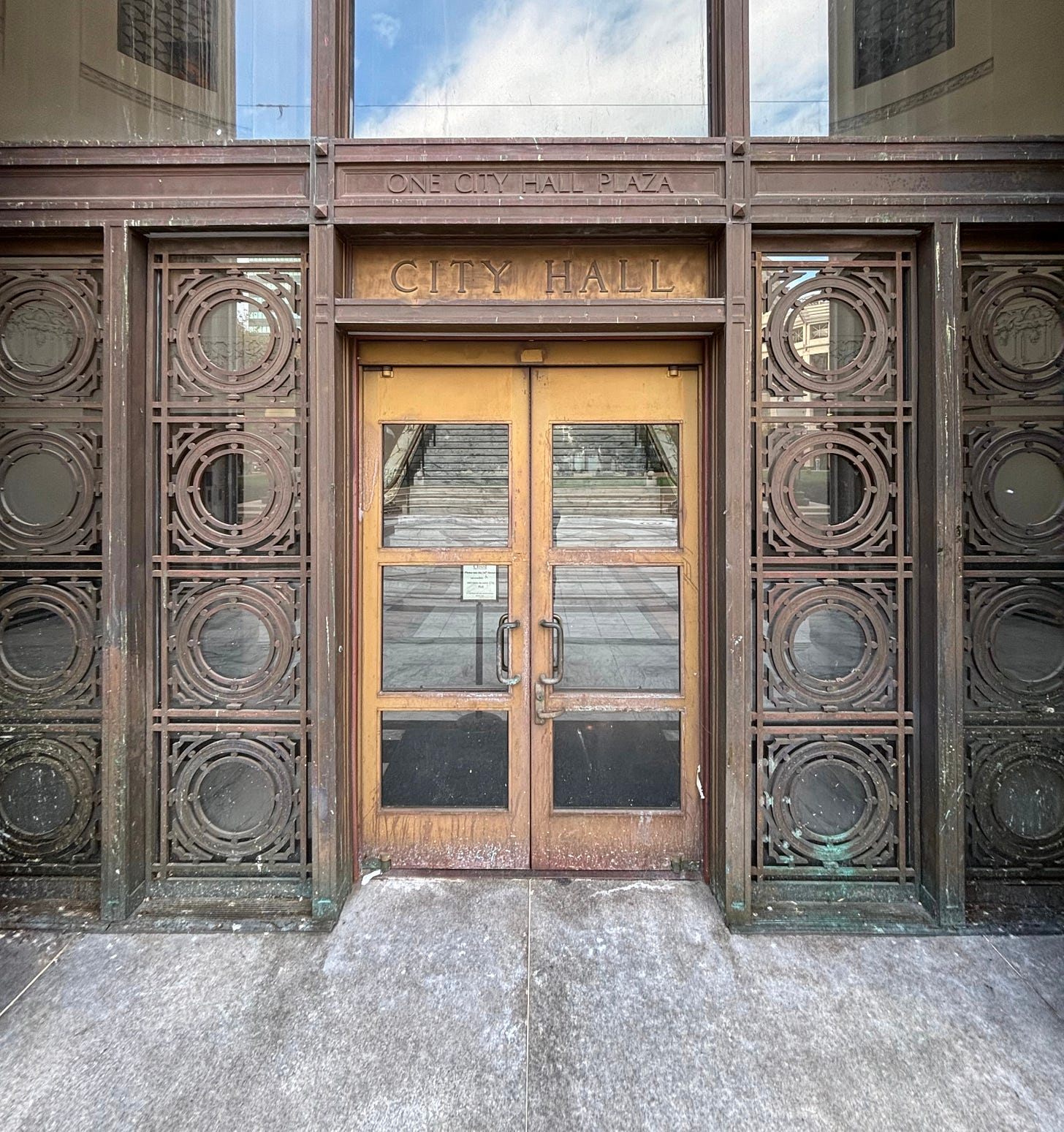 The front door to Oakland City Hall, with a closed sign indicating that this entrance is not in use and directing visitors to a side door. Oakland, California, November 6, 2025. (Image source: Oakland Report)