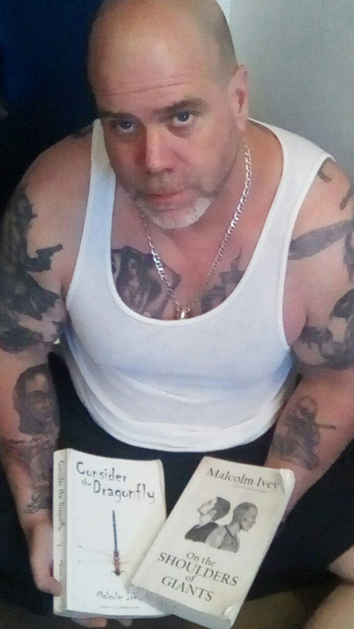 Me holding two of my books, Consider the Dragonfly and On the Shoulders of Giants.