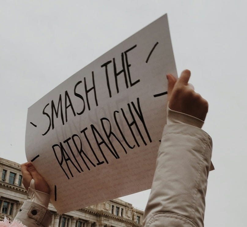woman holding white paper with smash the pairtarchy