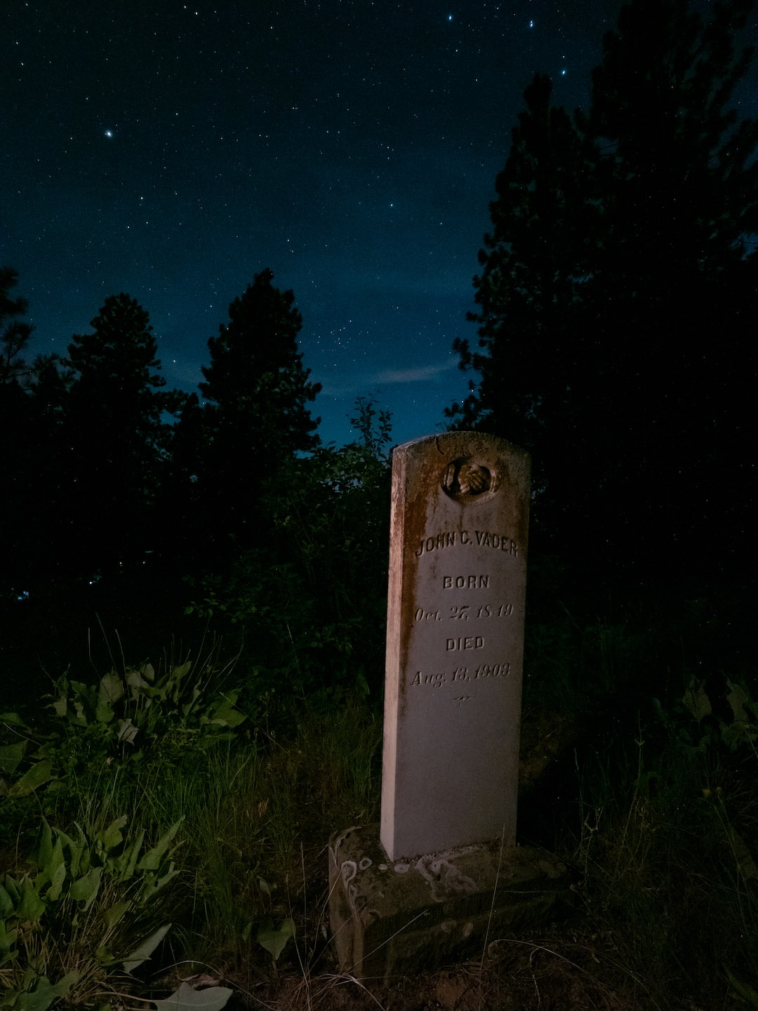 a tombstone in a grassy area