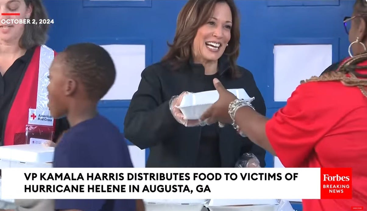 Kamala Harris smiles as she hands a hot meal in a foam container to a woman at a Red Cross aid station in Augusta, Georgia Kamala Harris smiles as she hands a hot meal in a foam container to a woman at a Red Cross aid station in Augusta, Georgia