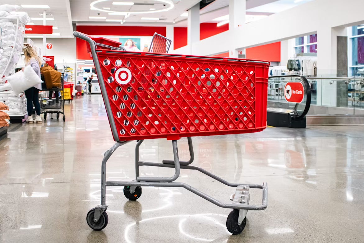 An empty red Target shopping cart in a store aisle. An empty red Target shopping cart in a store aisle.
