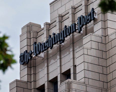 a sign on a building reads 'the washington post' a sign on a building reads 'the washington post'