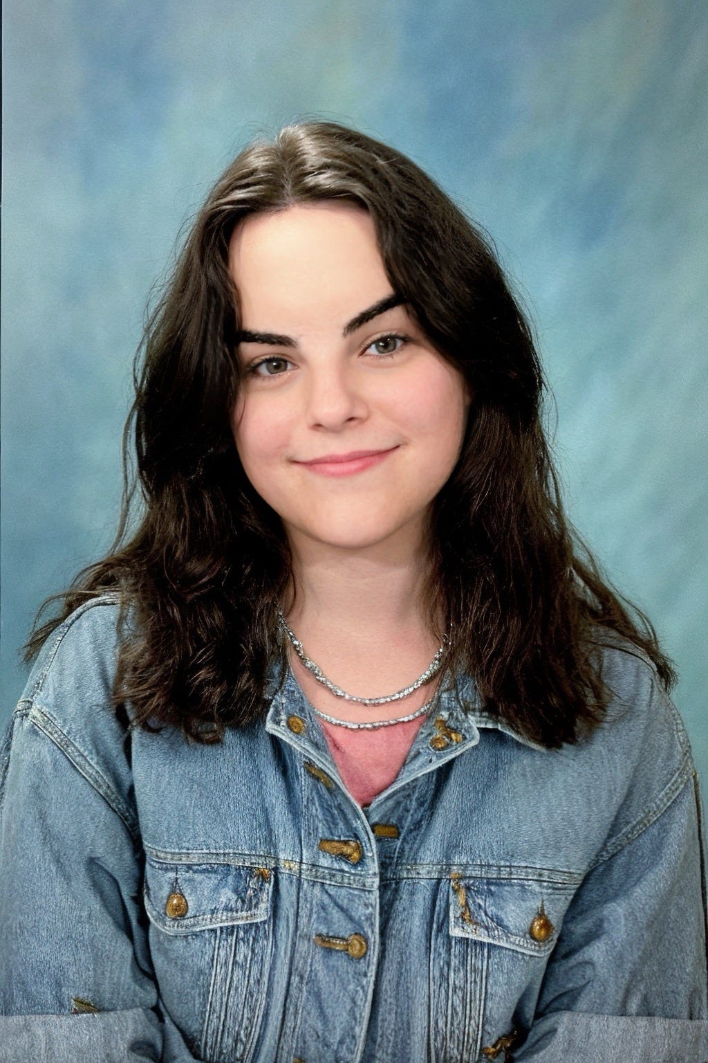 An AI image generated by Epik, showing a young, female version of myself, smiling and wearing a denim jacket.