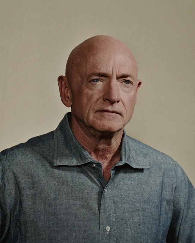 Mark Kelly in front of a tan backdrop