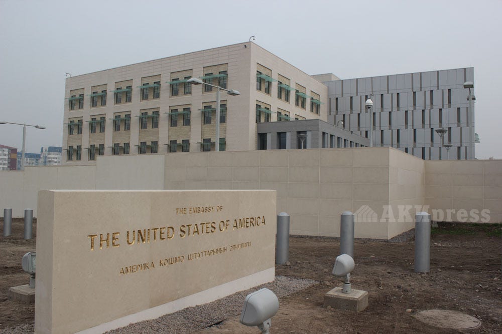 Exterior of the U.S. Embassy in Kyrgyzstan with a stone sign reading "The Embassy of the United States of America."