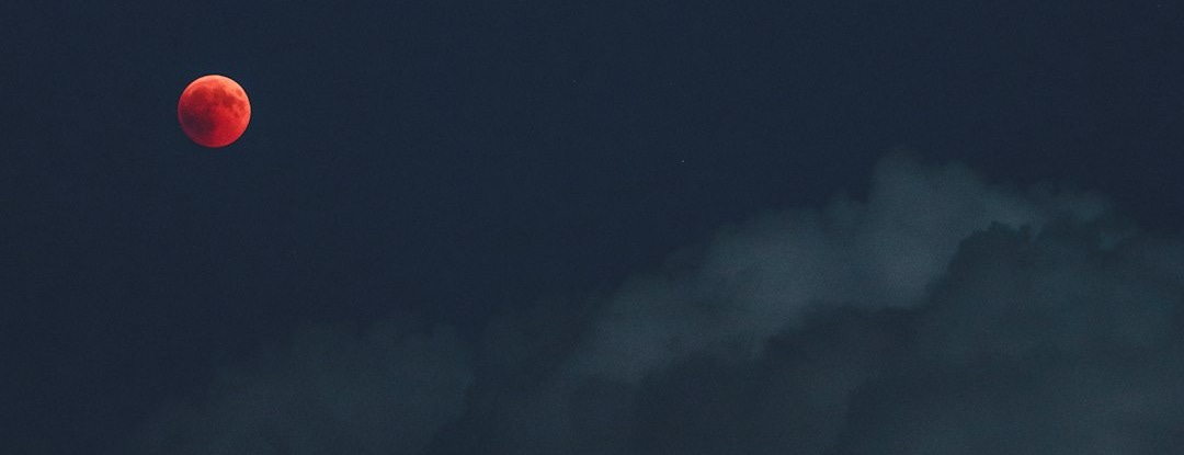 mountain under cloudy full moon
