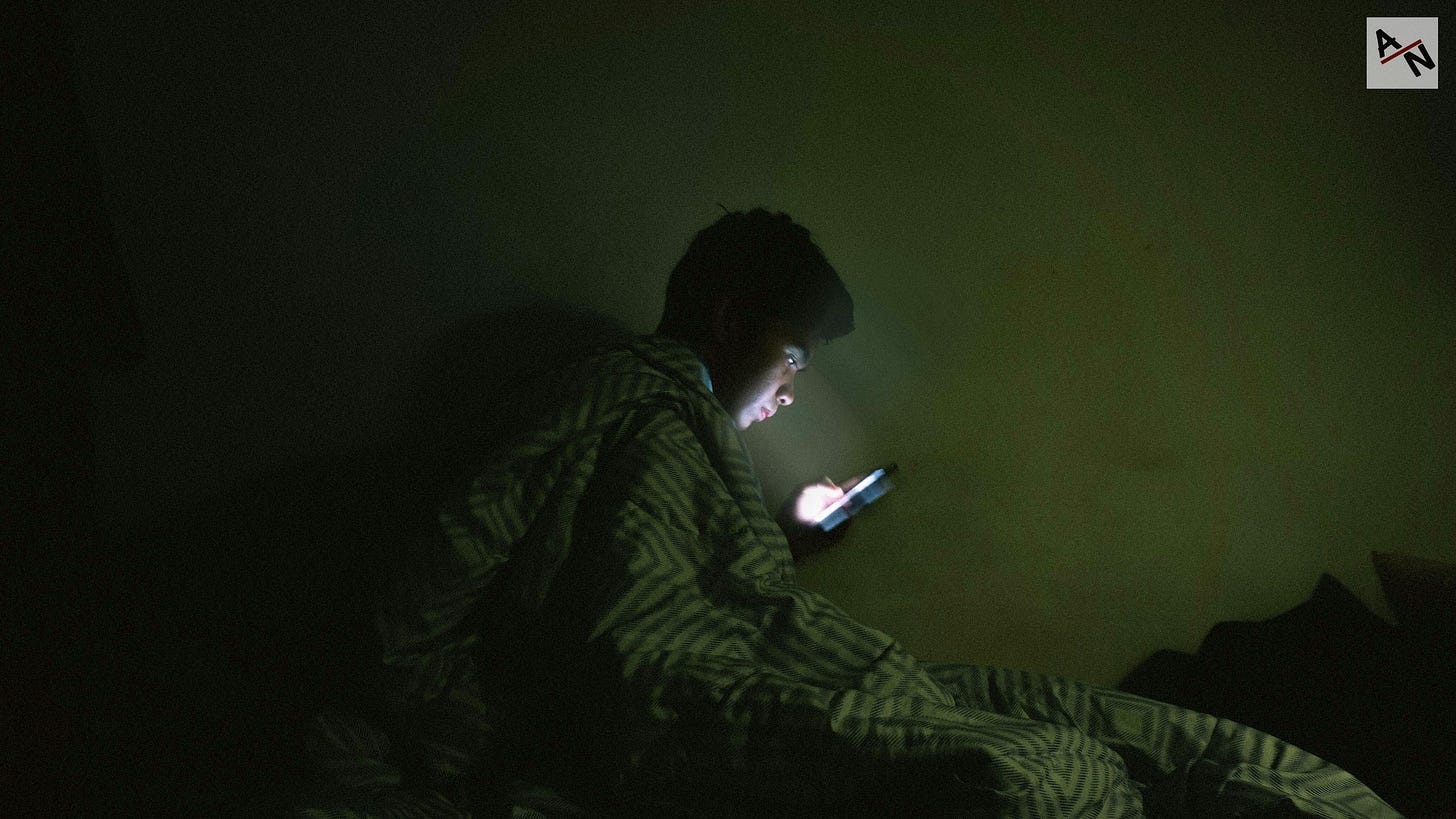 man using mobile phone while covering his body of blanket man using mobile phone while covering his body of blanket