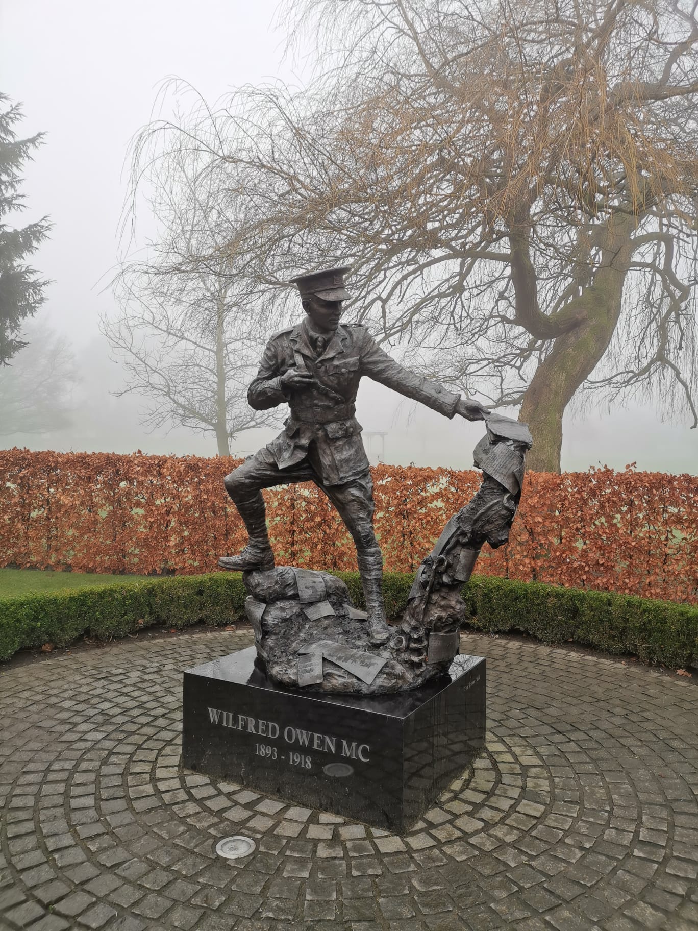 Statue of Shropshire’s WW I soldier-poet Wilfred Owen in the fog, memorial section of Cae Glas Park, Oswestry (photo by V.A. Smith, c. 2024) Statue of Shropshire’s WW I soldier-poet Wilfred Owen in the fog, memorial section of Cae Glas Park, Oswestry (photo by V.A. Smith, c. 2024)