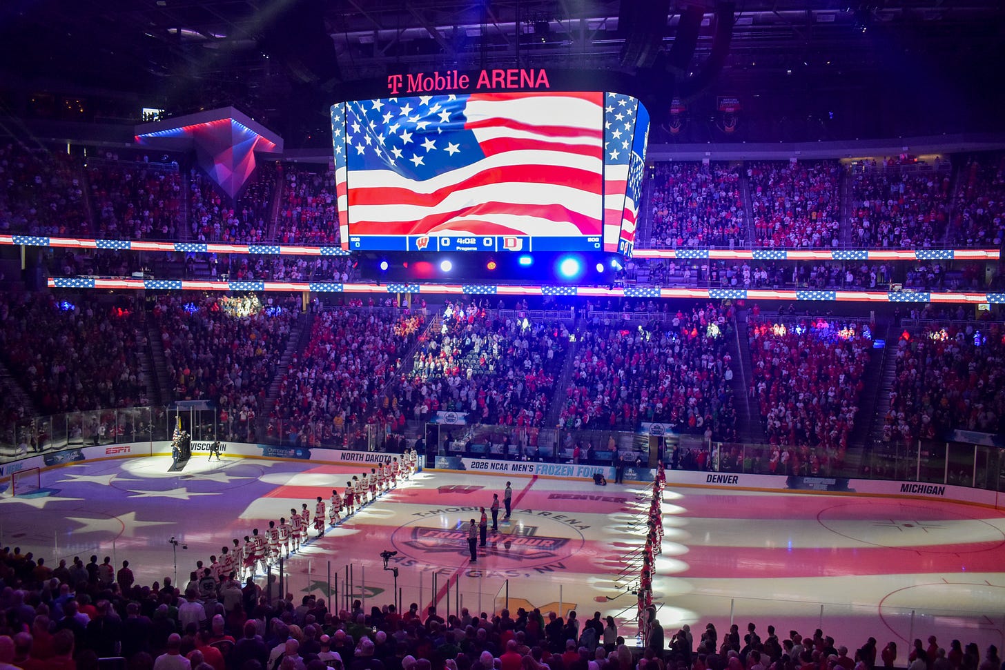 T-Mobile Arena starting lineups 2026 frozen four national championship. United States of America flag on scoreboard.