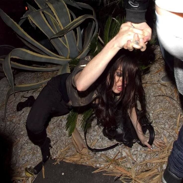 This may contain: a woman with long black hair is on the ground and has her hands up in the air This may contain: a woman with long black hair is on the ground and has her hands up in the air