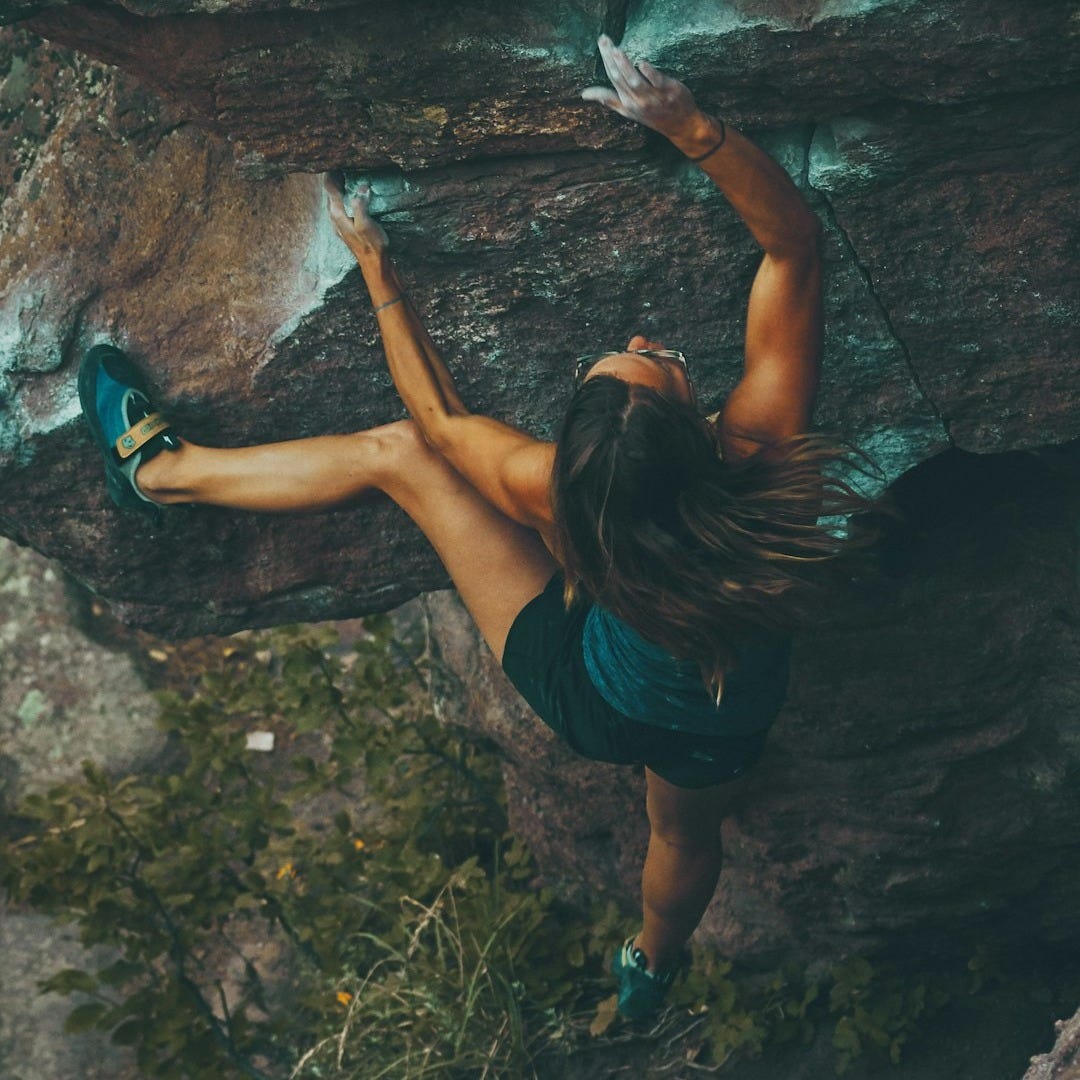 photo of woman climbing mountain
