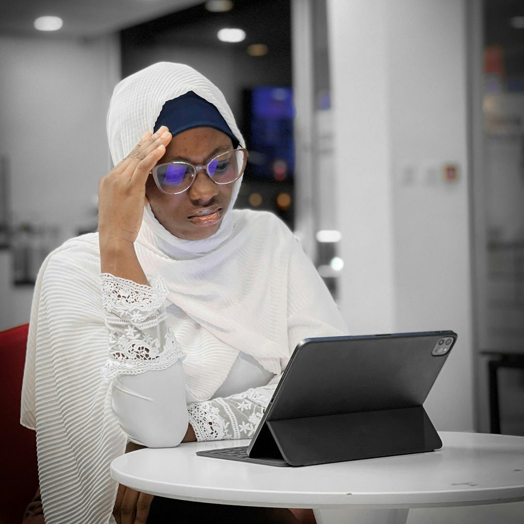 a woman sitting at a table with a laptop