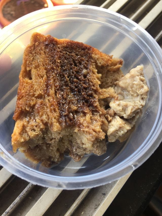 A cup of bread pudding with chocolate on top.