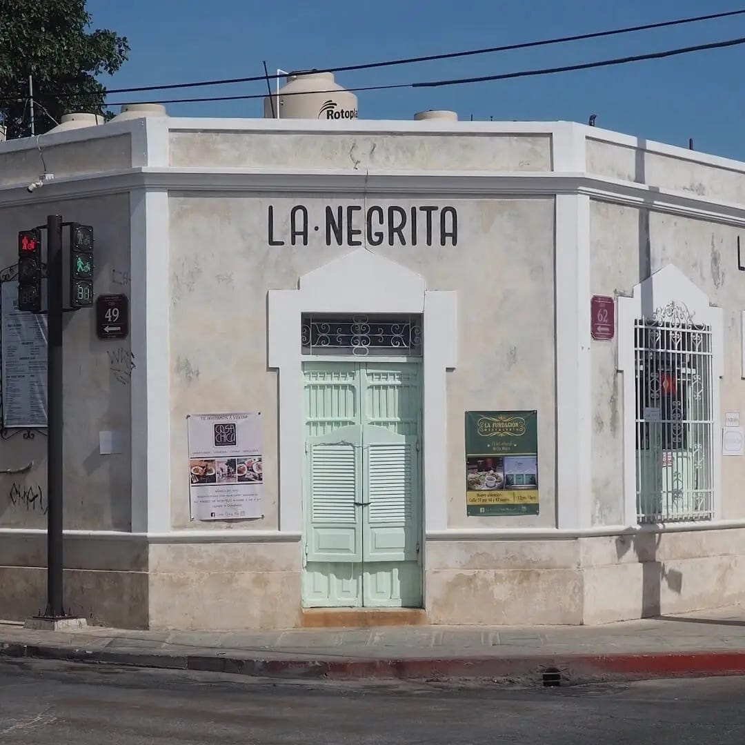 La Negrita, Merida, Mexico La Negrita cantina - a grey building with a green/blue stable door