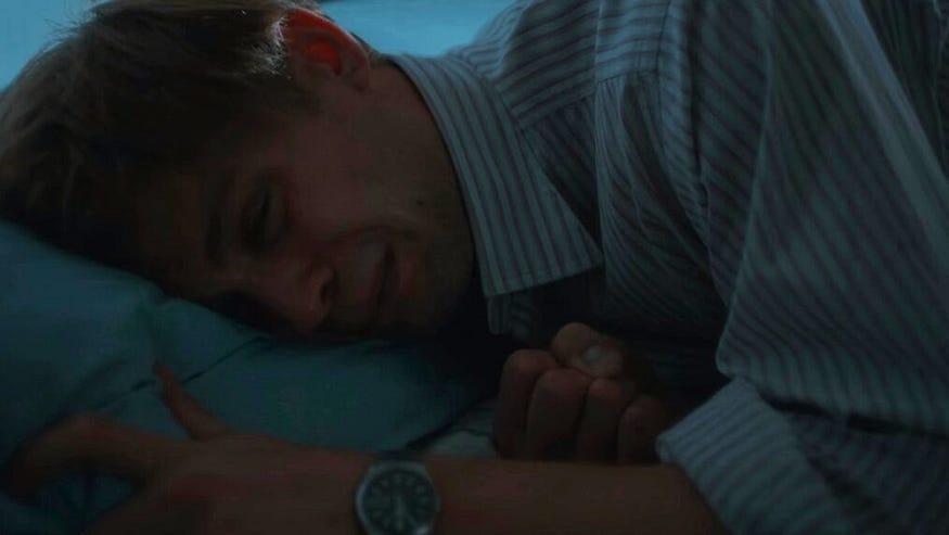 The character Dex crying in bed, grieving his loss.