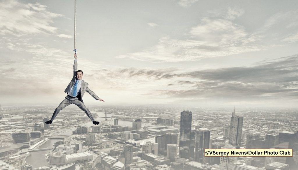 Man in a panic, hanging fro a cable