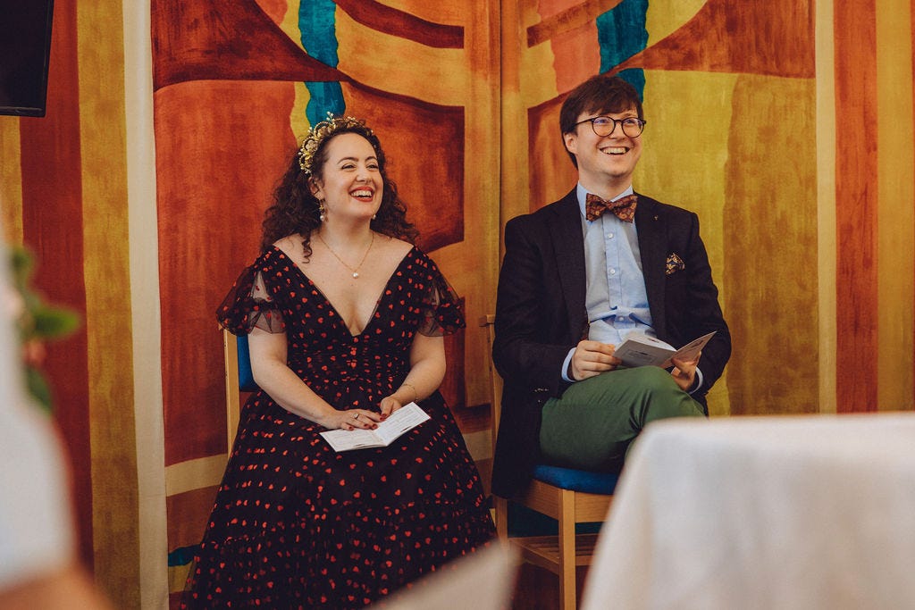 Natasha and Sebastian sitting on the bimah, laughing with the rabbi