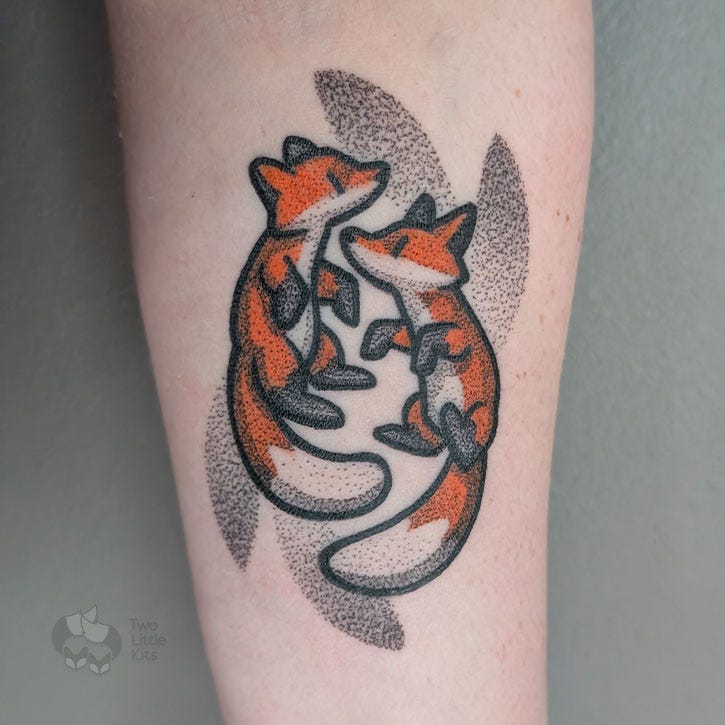 A tattoo of two foxes on a caucasion woman's inner arm. The style is cartoonish with bold outlines and dotted shading. A tattoo of two foxes on a caucasion woman's inner arm. The style is cartoonish with bold outlines and dotted shading.