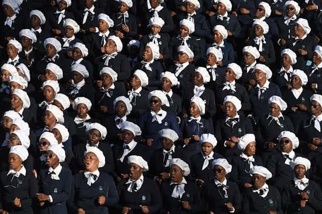 A mass of African women standing and singing in a choir 