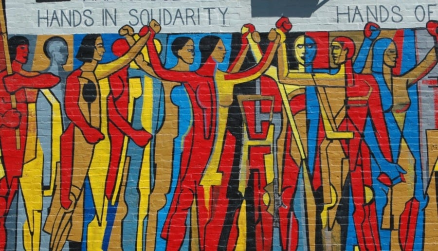 A wall mural of many different types of people holding hands