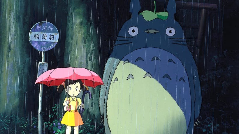 A young girl stands in the rain at a bus stop next to an adorable, huge critter named Totoro A young girl stands in the rain at a bus stop next to an adorable, huge critter named Totoro