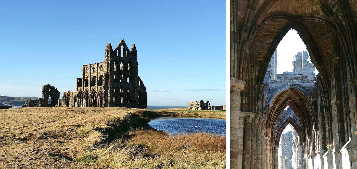 Photos of Whitby Abbey credited to Lewek-rafek (CC BY-SA 4.0). LEFT: Whitby Abby shot from afar with a rippling lake to the right. The front facade falls completely in shadow while the side is in sunlight. There are three levels of arches on the side. The bottom level are pointed, the middle rounded, and the top smaller rounded windows. The front has an additional level coming to a peak but the roof is missing. Beside it are the top of two towers. RIGHT: A photographic view through a series of three pointed arches. White light coming in bathes the stonework to the right. We see don’t see the base of the pillars forming the arches, just the upper portion. The first window through shows a broken upper level at its peak and the pale sky beyond. The view through the last arch is obscured by stonework. Photos of Whitby Abbey credited to Lewek-rafek (CC BY-SA 4.0). LEFT: Whitby Abby shot from afar with a rippling lake to the right. The front facade falls completely in shadow while the side is in sunlight. There are three levels of arches on the side. The bottom level are pointed, the middle rounded, and the top smaller rounded windows. The front has an additional level coming to a peak but the roof is missing. Beside it are the top of two towers. RIGHT: A photographic view through a series of three pointed arches. White light coming in bathes the stonework to the right. We see don’t see the base of the pillars forming the arches, just the upper portion. The first window through shows a broken upper level at its peak and the pale sky beyond. The view through the last arch is obscured by stonework.