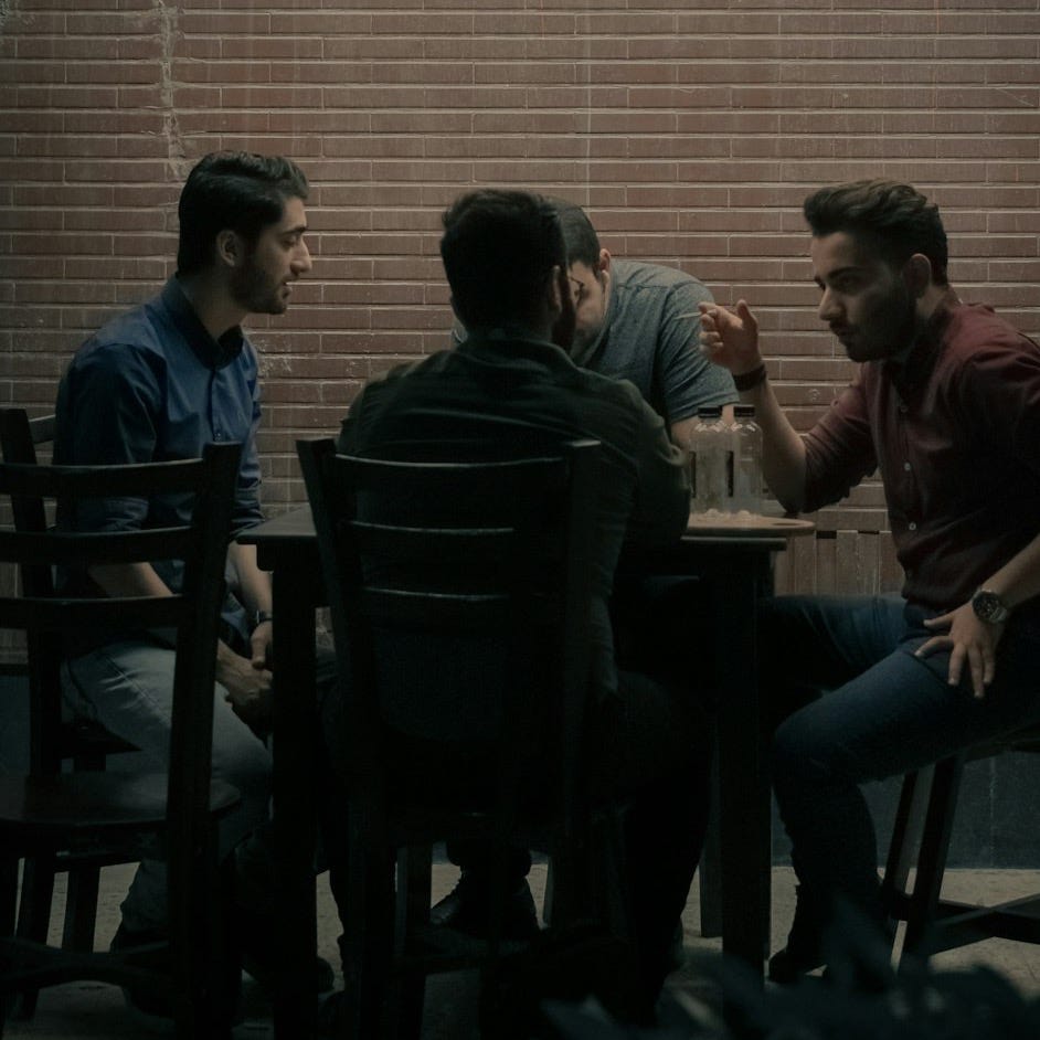 four men sitting beside table