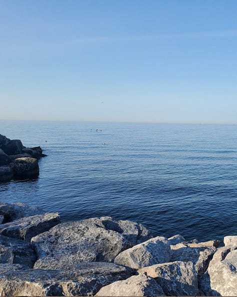 Three photos showing the lake showcasing mist, rock and sand.