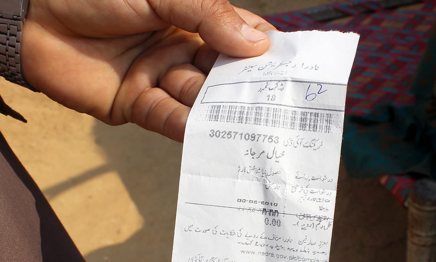 Marjana's son, Niaz Mohammad, shows the token his mother received from Nadra. — Photo by author