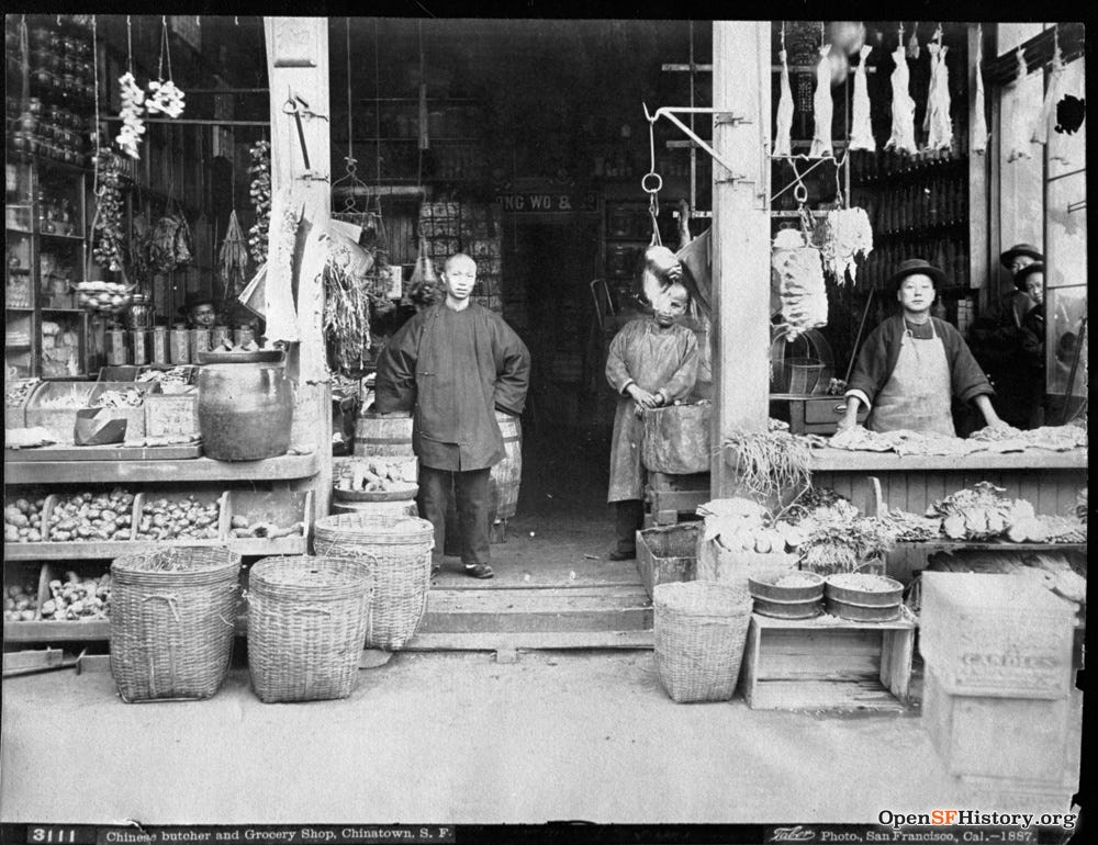 Black and white photograph. Chinese shopkeepers in the storefront of a grocery store. Black and white photograph. Chinese shopkeepers in the storefront of a grocery store.